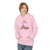 Person wearing a pink hoodie with a Christmas design and text on a white background