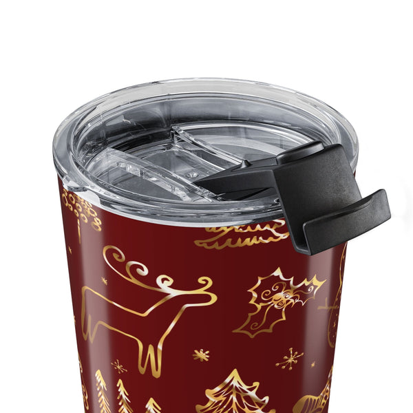 Red tumbler with gold reindeer and tree pattern on a white background