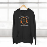 Black hoodie with autumn leaves and lattes design on a hanger against a white background