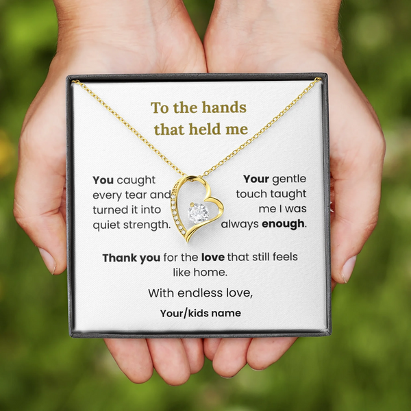 Necklace with heart-shaped pendant held by hands, displayed on a card with text.