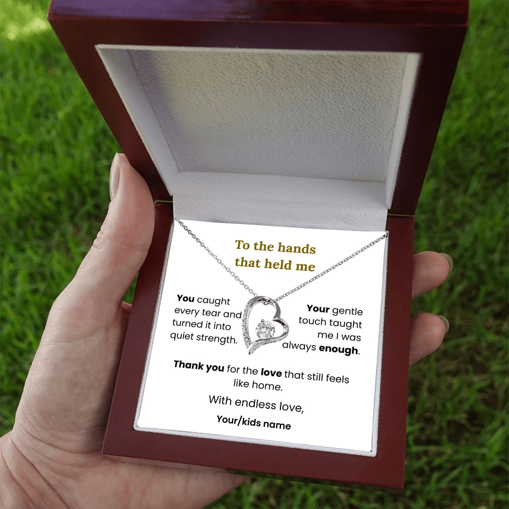 Necklace with heart pendant in a wooden box held by a hand on grass