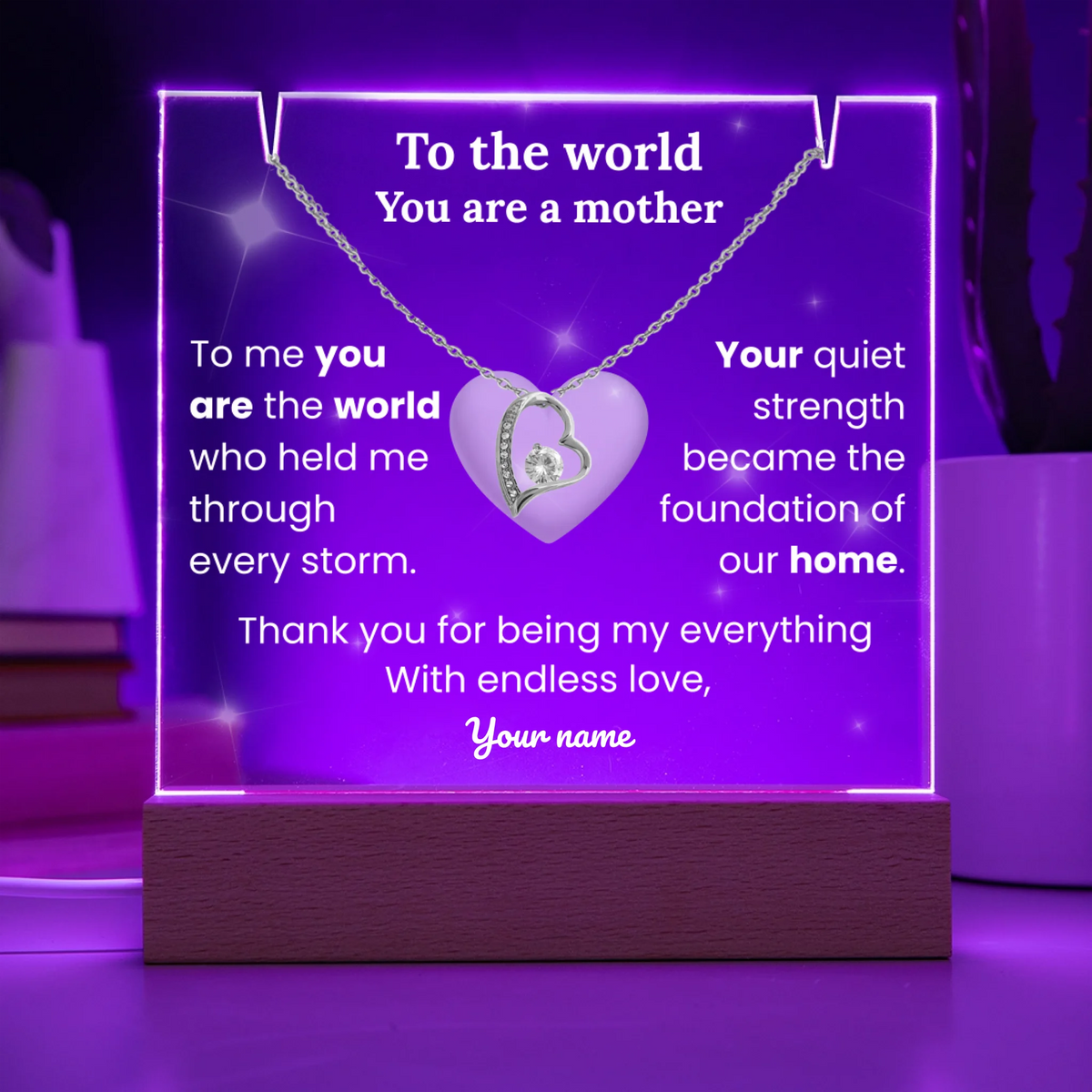 Necklace with heart pendant on a purple stand with engraved message