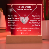 Heart-shaped necklace on a red background with engraved text