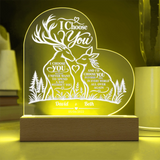 Personalized acrylic 3D LED night light with a deer and forest design, glowing with warm yellow light on a wooden base.