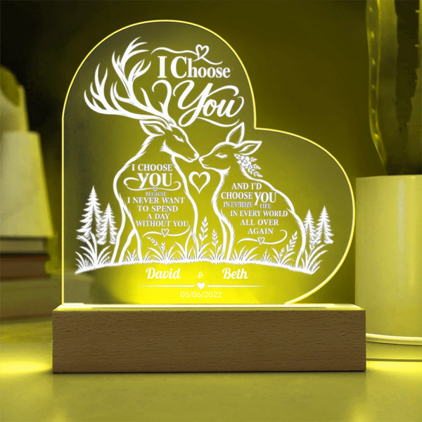 Personalized acrylic 3D LED night light with a deer and forest design, glowing with warm yellow light on a wooden base.