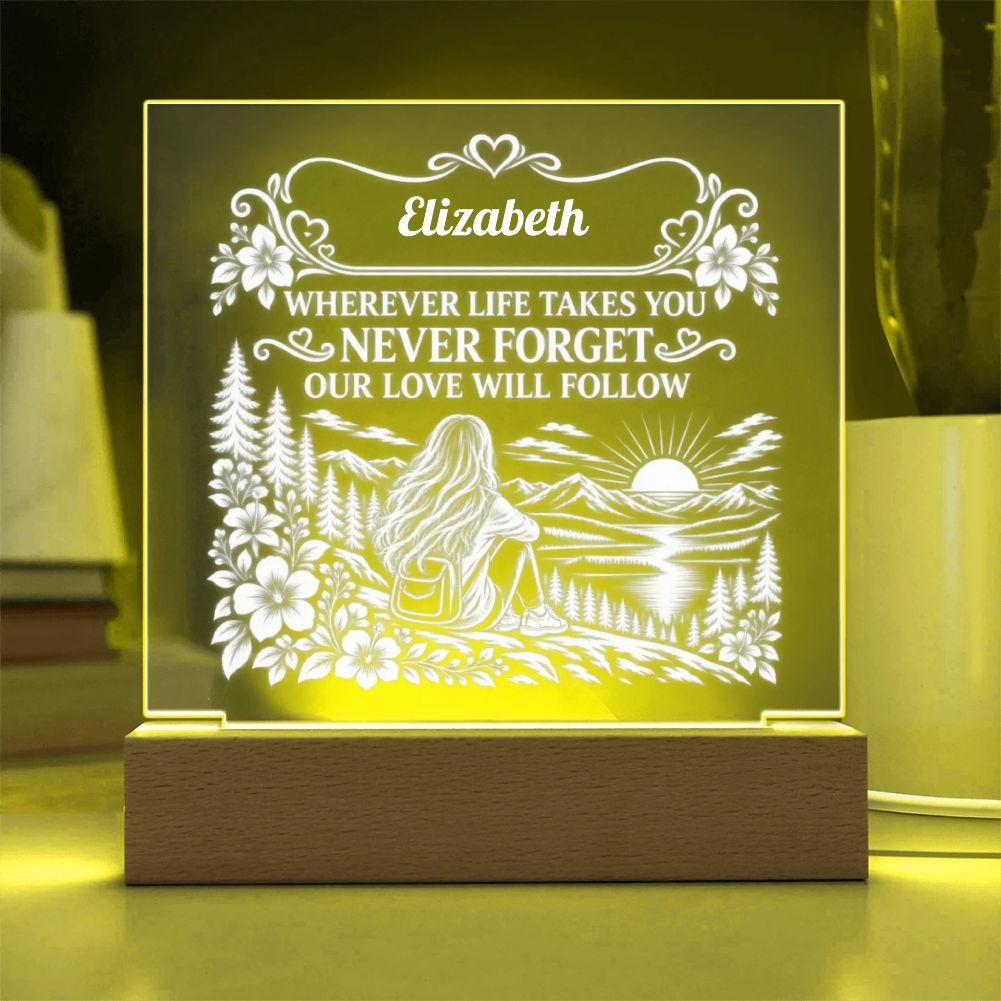 Personalized acrylic LED night light with a wooden base, featuring a scenic engraving of a woman sitting by a lake with mountains and flowers, and the text 'Elizabeth WHEREVER LIFE TAKES YOU NEVER FORGET OUR LOVE WILL FOLLOW', glowing with a warm yellow light.