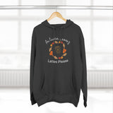 Black hoodie with autumn leaves and lattes design on a hanger against a white background