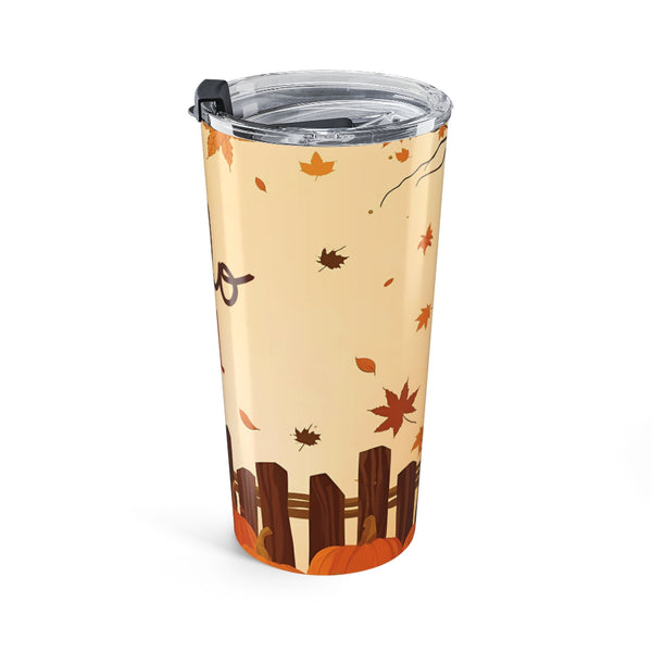 Tumbler with autumn design featuring leaves and a fence on a beige background