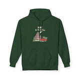 Green hoodie with a graphic of a house and truck and text 'Home for the holidays' on a white background