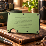 A rectangular light green metal card holder with pre-drilled screw holes and a curved cutout at the bottom, displayed on a brown leather wallet. The card holder features a printed sentimental message for Dad in black text.