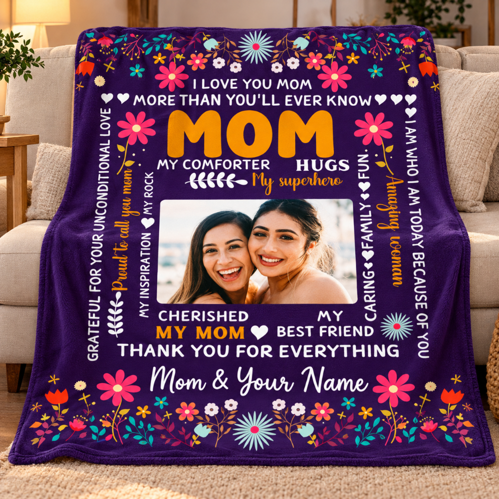 A purple personalized blanket with colorful floral borders and sentimental text, draped over a sofa. The center has a photo frame area showing two women smiling, with customizable text sections around it.