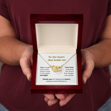 woman holding yellow gold interlocking heart necklace in lux box