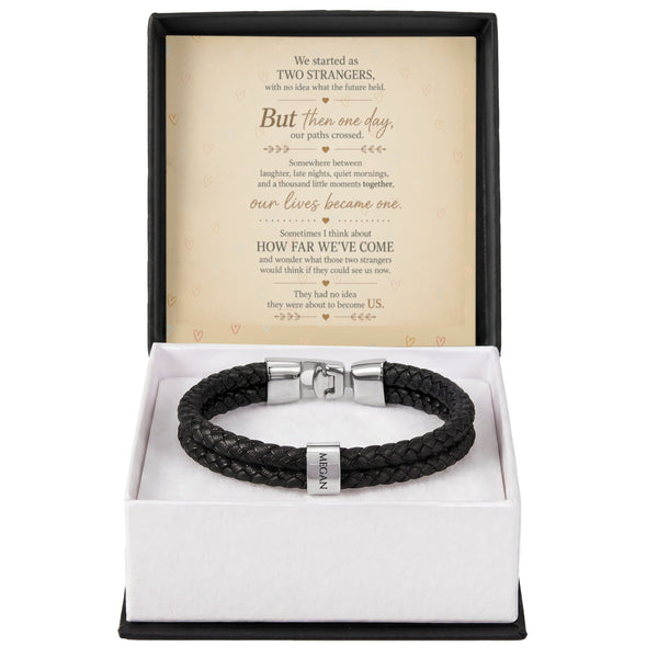 A black braided leather bracelet with silver-toned metal hardware, presented in an open white gift box with a black outer base. The inside lid features a printed sentimental message card.