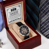 Watch in a wooden box with a romantic message, surrounded by ties on a white background