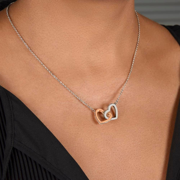 Necklace with a heart-shaped pendant on a person wearing a black top.