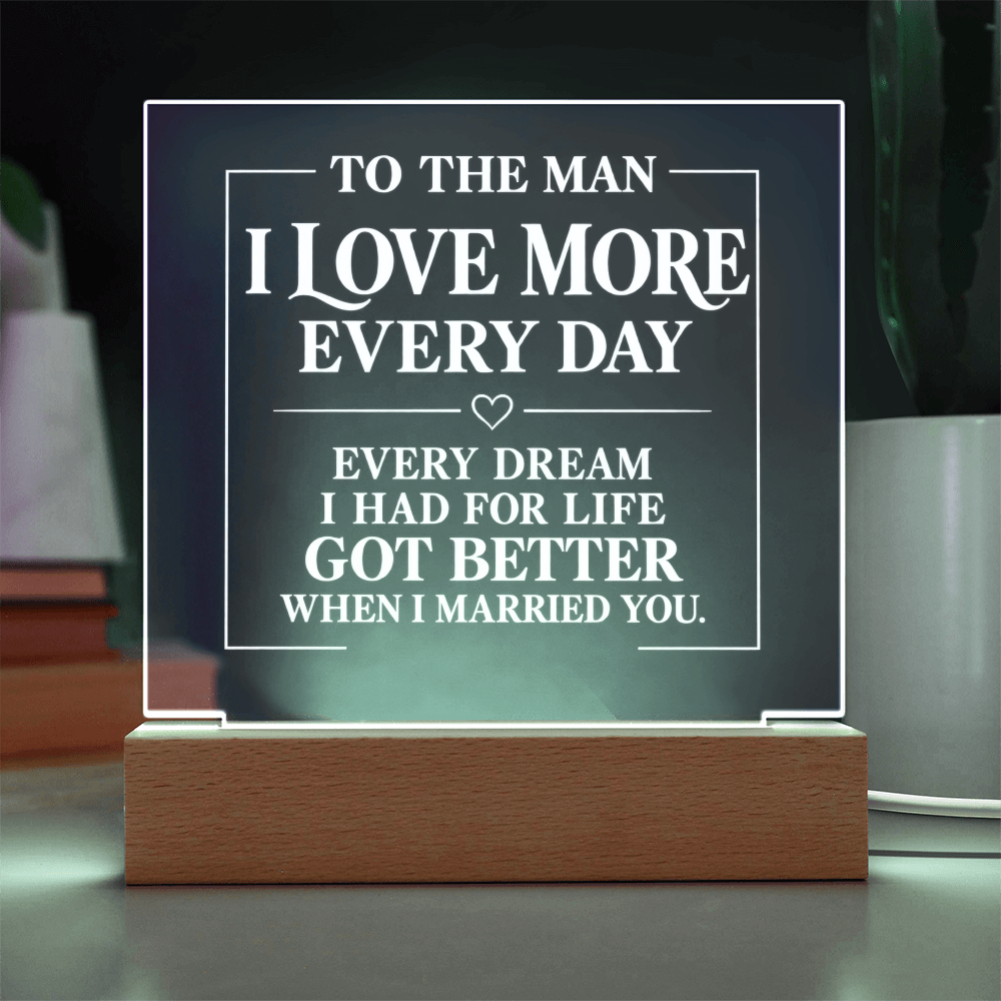 A rectangular acrylic LED night light with a wooden base, displaying a romantic message for a husband. The text reads 'TO THE MAN I LOVE MORE EVERY DAY' and 'EVERY DREAM I HAD FOR LIFE GOT BETTER WHEN I MARRIED YOU.