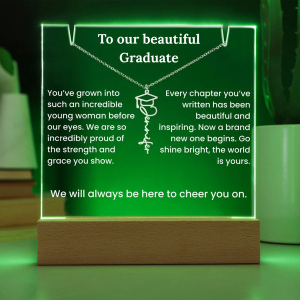 Graduation-themed plaque with green lighting and wooden base, featuring a message to a graduate.