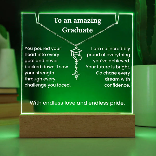 Decorative sign with engraved message for a graduate on a wooden stand with green glowing border.