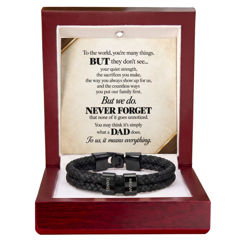 A black braided cord bracelet with silver-toned metal clasps engraved with the names 'DAVID' and 'IAN', presented inside an open reddish-brown wooden gift box with a printed memorial message card.