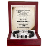 A black braided cord bracelet with silver-toned engraved beads and a clasp, presented inside an open dark red wooden gift box. The box contains a cream-colored message card with a poem dedicated to Dad.