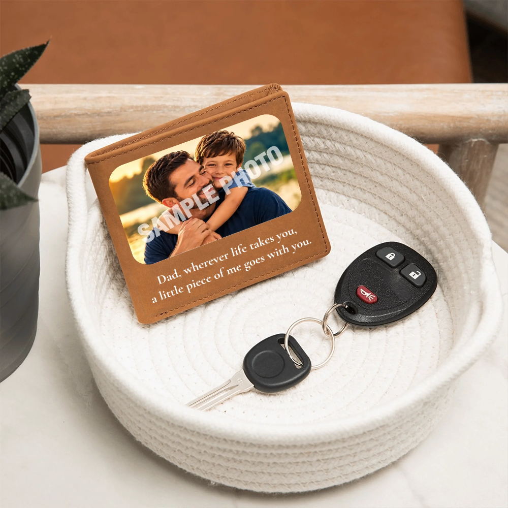 A personalized leather keychain wallet card with a photo of a father and son and a sentimental message, displayed in a white woven basket next to a car key fob and keys.