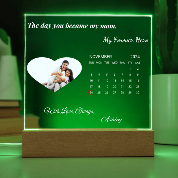 Personalized calendar with a photo of a woman and child, text 'The day you became my mom, My Forever Hero' on a green background.