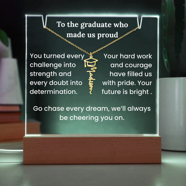 Decorative plaque with a necklace and graduation cap charm, featuring an inspirational message on a wooden base.