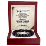 A black braided cord bracelet with silver letter beads inscribed with 'I LOVE YOU', presented inside an open dark red wooden gift box with a printed memorial message card.