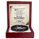 A black braided cord bracelet with three black metal name tags engraved with 'DAD', 'MATHER', and 'FATHER', presented inside an open dark red wooden gift box with a sentimental poem printed on the insert card.