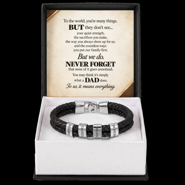 A black braided leather bracelet with silver metal beads and engraved name plates, presented in a white gift box with a black outer sleeve. The inside sleeve features a printed message card for Father's Day.