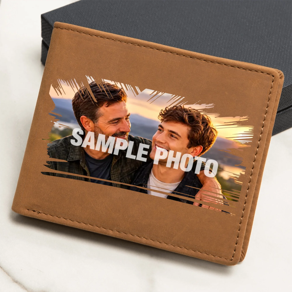 A brown faux-leather bifold wallet shown at an angle on a light marble surface with a dark box behind it. The front has a printed sample photo of two men with the text 'SAMPLE PHOTO' overlaid in white.