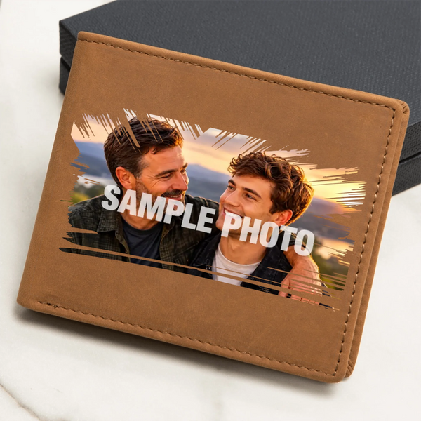 A brown faux-leather bifold wallet shown at an angle on a light marble surface with a dark box behind it. The front has a printed sample photo of two men with the text 'SAMPLE PHOTO' overlaid in white.