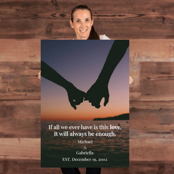 Person holding a poster with hands holding hands at sunset and a quote.