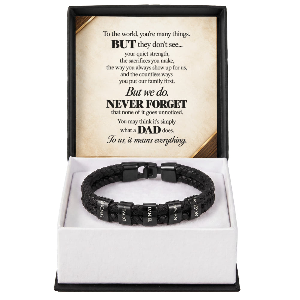 A black braided cord bracelet with silver-toned letter beads spelling out 'I LOVE DAD', presented in a white gift box with a black outer frame. The inside lid features a sentimental message for Dad printed in black text on a beige background.
