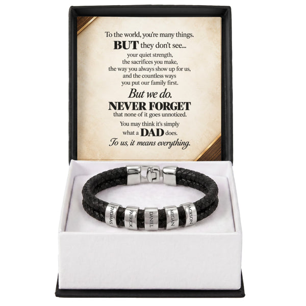 A black braided cord bracelet with silver-toned engraved beads, presented in a white box with a black outer frame. The inside lid features a printed message for Dad.