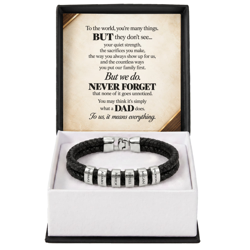 A black braided cord bracelet with silver-toned beads engraved with 'I PRAISE' and 'I HONOR' is presented in an open gift box with a white interior and a black outer frame. The back insert card features a sentimental message for a father.