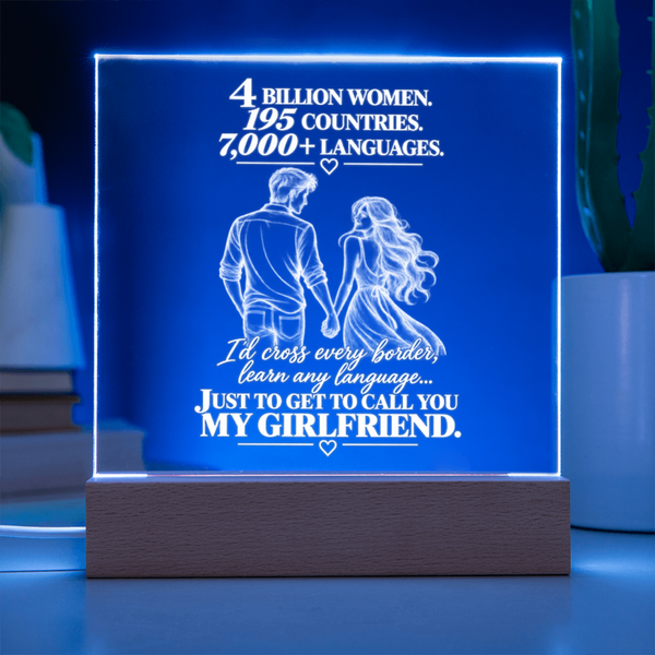 A rectangular LED lamp on a wooden base displaying a romantic message in white text and a couple holding hands, glowing with a blue light in a softly lit room.