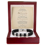A black braided leather bracelet with silver-toned metal bands engraved with 'ORION' and 'KARMA', presented inside an open dark red wooden gift box with a white insert and a printed sentimental message card.