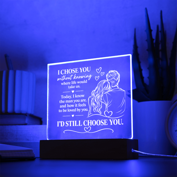 A rectangular acrylic LED light box on a black base, glowing with a blue-purple light. The front has white engraved text reading 'I CHOSE YOU without knowing where life would take us.