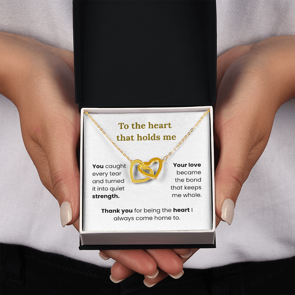 woman holding yellow gold interlocking heart necklace with two-tone box