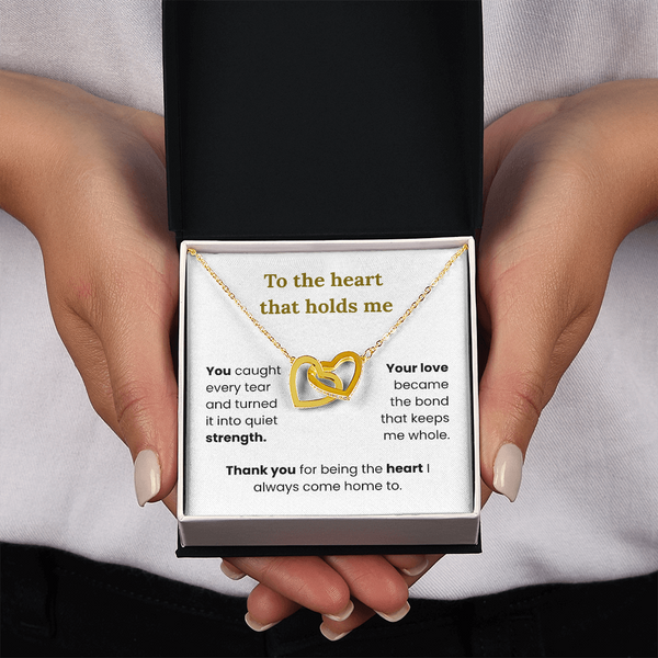 woman holding yellow gold interlocking heart necklace with two-tone box