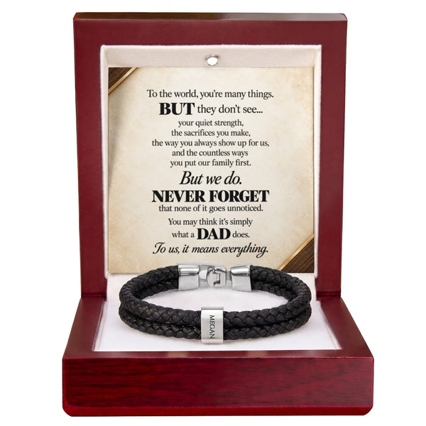 A black braided leather bracelet with a silver-toned magnetic clasp and a small engraved name tag, displayed inside an open reddish-brown wooden gift box. The box contains a printed memorial message card addressed to a father.