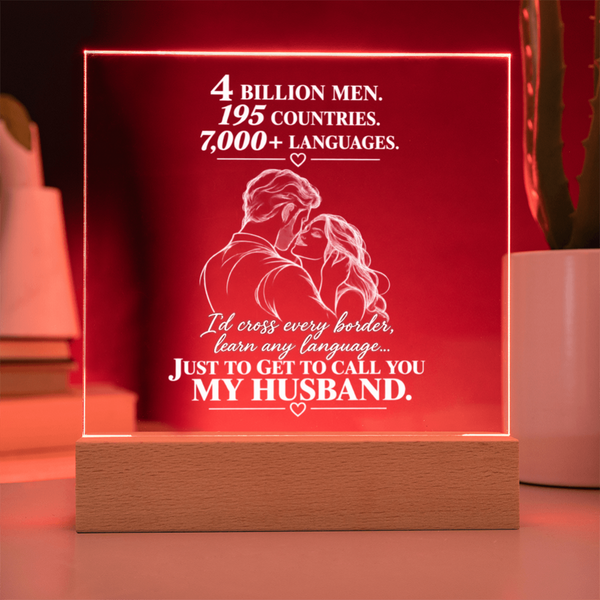 A rectangular acrylic LED light sign on a wooden base, glowing red with white text that reads, '4 BILLION MEN, 195 COUNTRIES, 7,000+ LANGUAGES. I'd cross every border, learn any language.