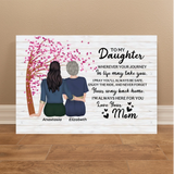 A personalized canvas wall art print leaning against a beige wall on a wooden floor. The print features a white wood-plank background with a black typewriter-style font poem addressed to a daughter, an illustration of two women sitting together under a pink cherry blossom tree, and the names 'Anastasia' and 'Elizabeth' printed below.