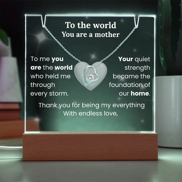 Heart-shaped necklace on a glowing stand with sentimental text