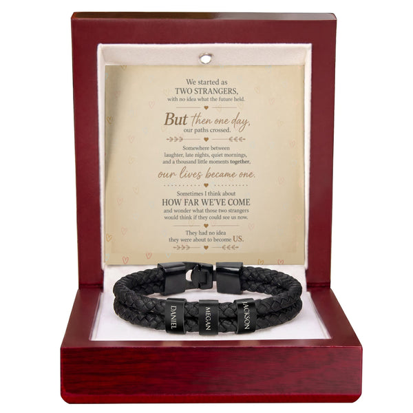A black braided leather bracelet with a black metal clasp engraved with 'I.V.