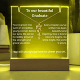 Decorative plaque with engraved message and necklace design, glowing yellow light.