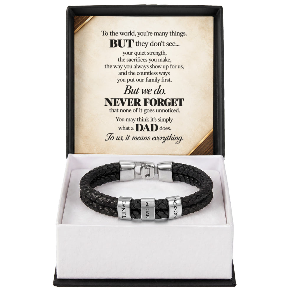 A black braided leather bracelet with silver metal accents engraved with 'DAD', 'HONOR', and 'LOVE', presented in a white box insert with a black outer frame and a sentimental message card inside.