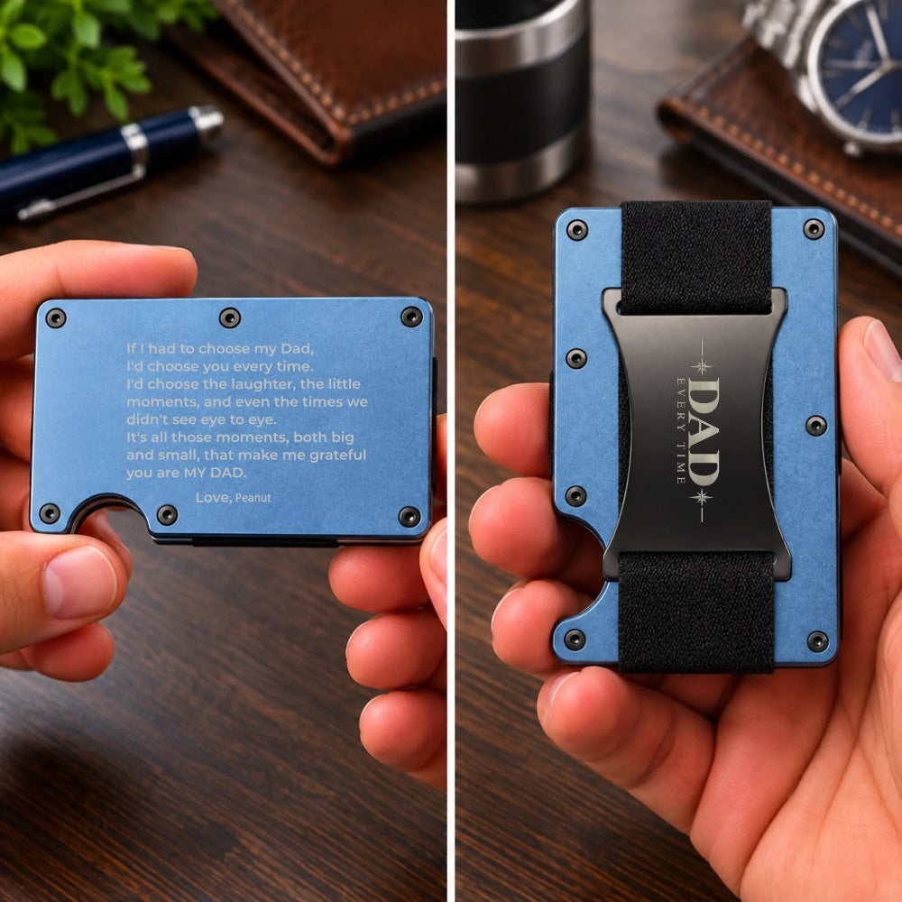 A split-screen close-up of a blue metal card holder wallet being held in a hand. The left side shows the front with engraved white text and a small cutout, and the right side shows the back with a black fabric strap and a black metal clip labeled 'DAD WITH LOVE.