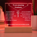 Decorative plaque with a necklace design and graduation message on a wooden base.